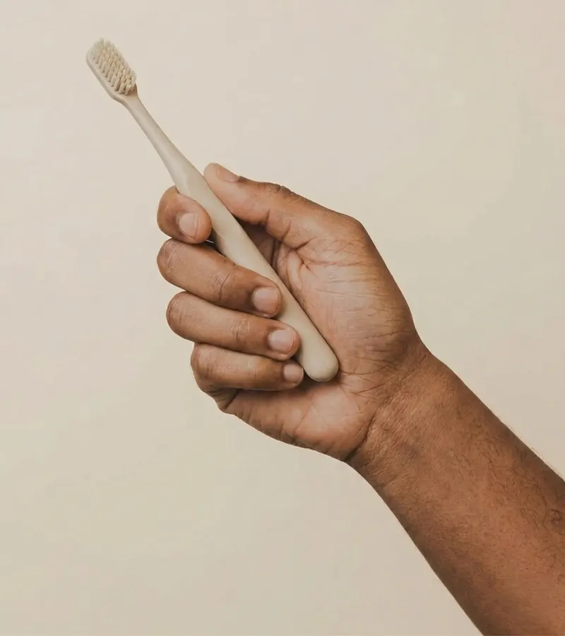 Mano sosteniendo un cepillo de dientes