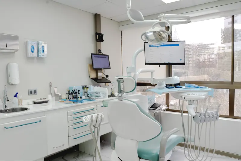 Box de atención con sillón dental y ventanal con vista a la ciudad