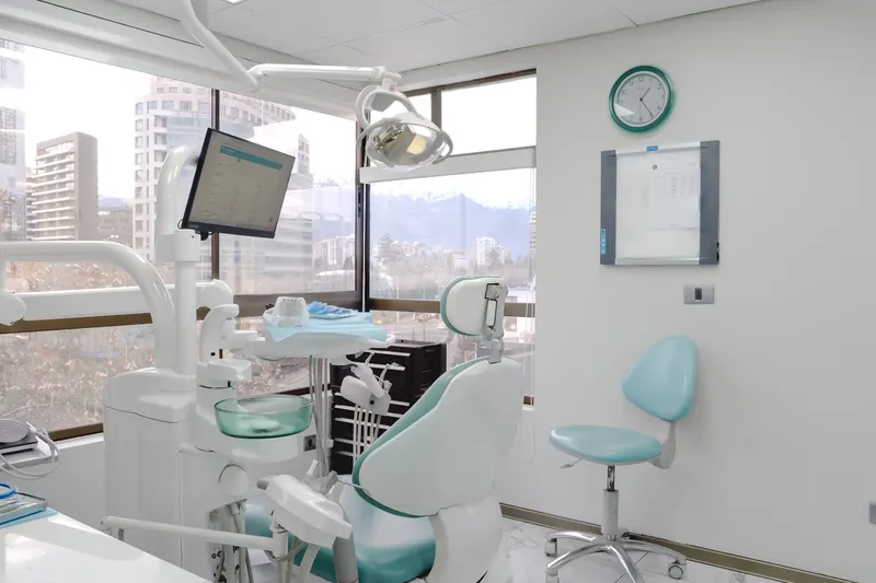 Box de atención con sillón dental, lámpara y ventanal