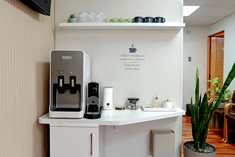 Rincón de café para pacientes con dispensador de agua y plantas